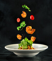 Shrimps falling on a plate of vegetables