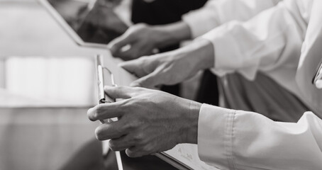 Fototapeta premium Healthcare medical doctor using tablet and smartphone for consult patient online: Physician working in hospital e-healthcare telemedicine Digital health in black and white technology concept.