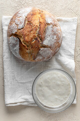 Wheat sourdough starter and homemade bread. Vertical orientation. Flat lay.