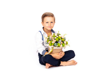 Cute boy child with a bouquet of flowers on a white isolated background