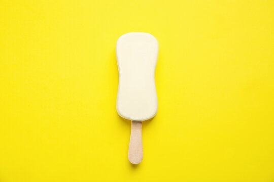 Ice cream with glaze on yellow background, top view