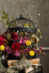 A close up of metal black cage with floral arrangement