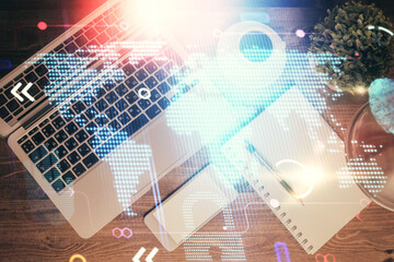 Double exposure of map hologram drawing over study table background with computer. Concept of international network. Top view.