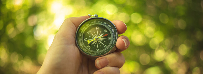Orienteering in the woods with compass in the hand, banner photo - Powered by Adobe