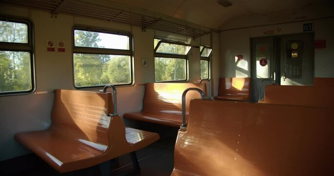interior of an empty train moving along the trees, orange seats
