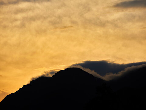 Clouds hug the mountain tops in a sunset image in the Rocky Mountains