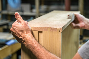 Woodworker fitting together dovetail joints.