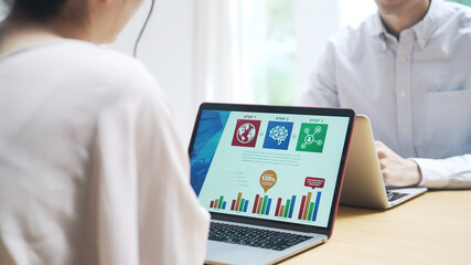 テーブルでパソコンを使う男女