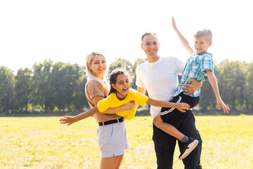 Fototapeta premium Happy family enjoying life together at meadow outdoor.
