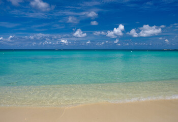 Kristallklares Wasser und rosafarbener Sand am leeren sieben Meilen langen Strand auf der tropischen Karibikinsel Grand Cayman