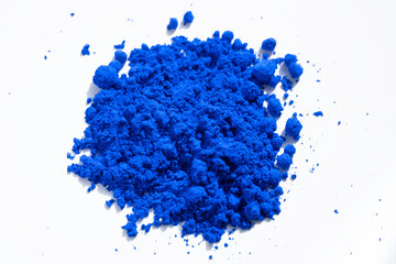 Close up of a portion of blue pigment isolated on white seen from above. The pigment will be mixed...