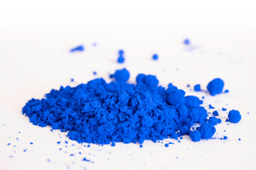 Close up of a portion of ultramarine , cobalt or indigo blue pigment isolated on white in side view. The pigment will be mixed with linseed oil to make oil paint - obrazy, fototapety, plakaty