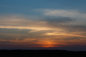 Sunset inMoscow oblast, Russia. Blue clouds. Orange sun strip.