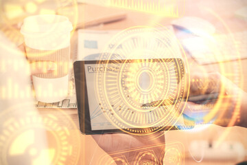 Double exposure of man's hands holding and using a digital device and tech theme hologram drawing. Technology concept.