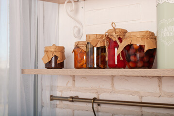 Wooden shelf table above a blurry kitchen window sill to display the product. On the shelf are crystal pink glasses with space for text