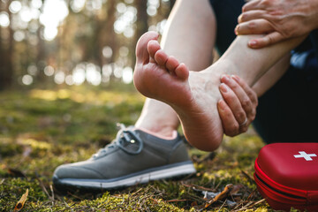 Sprain ankle during hiking in nature. Woman feeling pain after accident injury outdoors