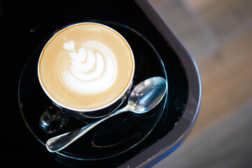 a cup of late coffee with flower shape design on top at cafe 