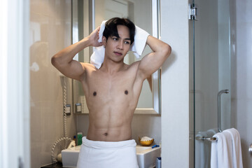 Fototapeta na wymiar Asian young handsome man holding towel in bathroom
