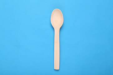 Wooden culinary spoon on blue background