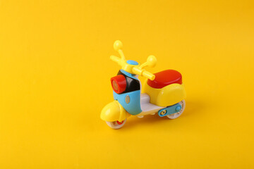 Toy scooter model close up on yellow background