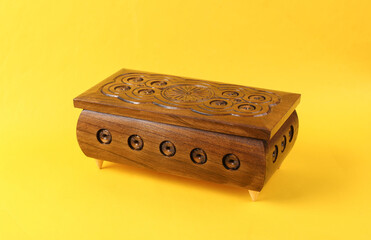Wooden carving jewelry box on yellow background