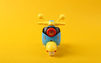Toy scooter model close up on yellow background