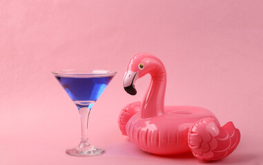 Inflatable pink flamingo with cocktail on pink background. Pool party. Summer minimal concept