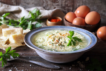 Italian cuisine. Stracciatella soup: parsley, eggs, olive oil and parmesan cheese
