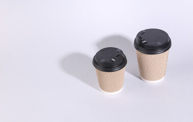 Two cardboard coffee cups on a gray background