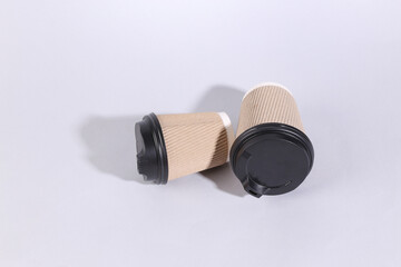 Two cardboard coffee cups on a gray background