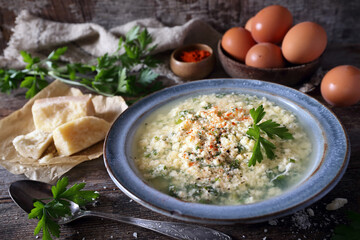 Italian cuisine. Stracciatella soup: parsley, eggs, olive oil and parmesan cheese