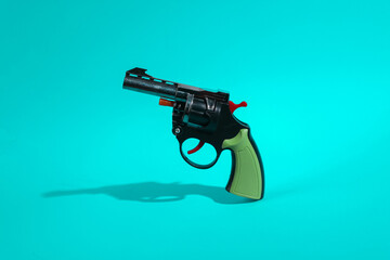 Toy gun on turquoise background