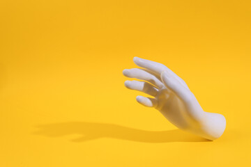 Plastic white hand on yellow background