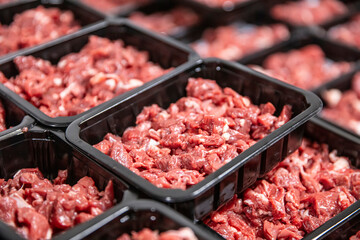 Fresh raw diced red beef meat (chopped in cubes) in a styrofoam container with copy space for text.