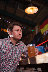 Vertical portrait of a man drinking beer at bar counter