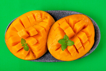 Mango fruit flesh cut into cubes on green. Ripe fruit served