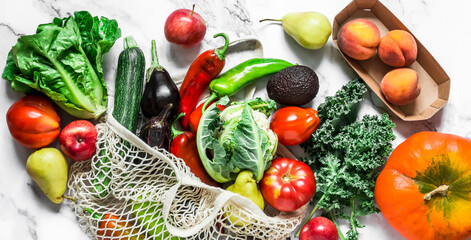 Food background banner. Seasonal vegetables on a marble background - kale cabbage, zucchini, eggplant, pepper, cauliflower, tomatoes, pumpkin and pears, apples, peaches. Top view, flat lay