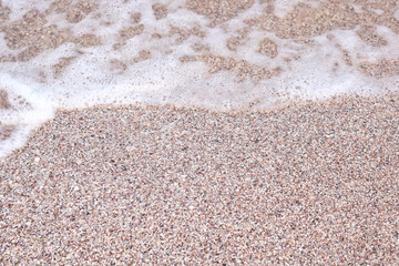Beautiful summer background for greeting card or advertising image with fine sand on beach and sea foam close up