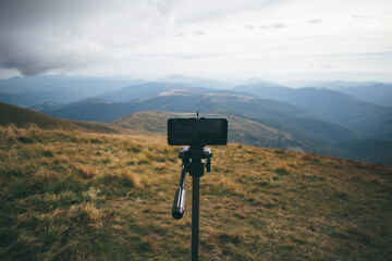 smartphone on a tripod captures a mountain landscape
