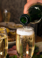 Wine pour in a glass. Man pouring champagne into a glass at a celebration, close up