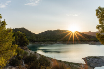 Sunset in a swamp, with the sun setting behind the mountains. 