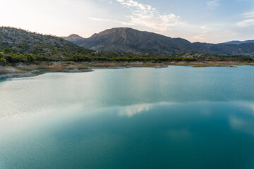 Sunset in a swamp, with the sun setting behind the mountains. 