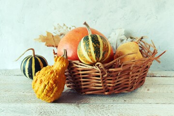Pumpkins in a wicker basket on a wooden table, Thanksgiving, Harvesting, Autumn, Halloween