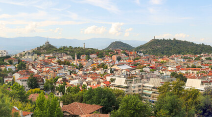 Fototapeta na wymiar panoramic landscape of Plovdiv from the old town with views of the entire city from above - tourist postcard for a wallpaper with the buildings and monuments, the hills, mountains and a blue sky