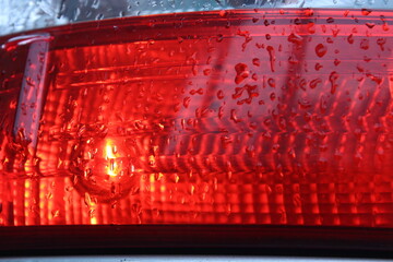 Water droplets on the rear light of the car. Macro. Russia.
