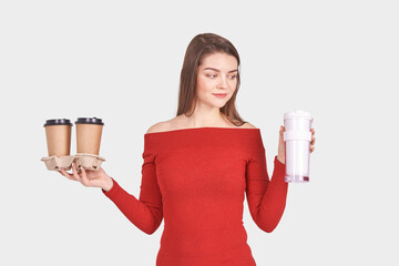 Pretty young woman with coffee cup. Studio portrait. Ecology concept. Female person holding reusable mug. Americano, latte drink. Student breakfast. Takeaway beverage. Isolated background. Zero waste