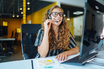 Meeting online. Young woman wearing headphones using laptop watching webinar or doing video chat by...