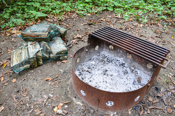 Firewood in mesh bag for brazier on campsite.