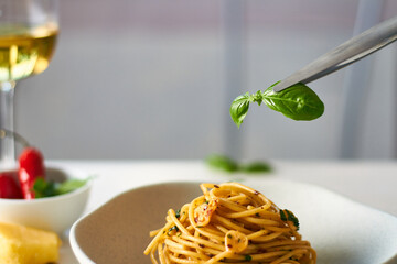 spaghetti pasta aglio e olio with chili flakes parsley garlic decorating with basil