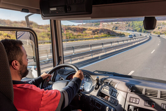 Truck driver driving on the highway, seen from inside the cab.